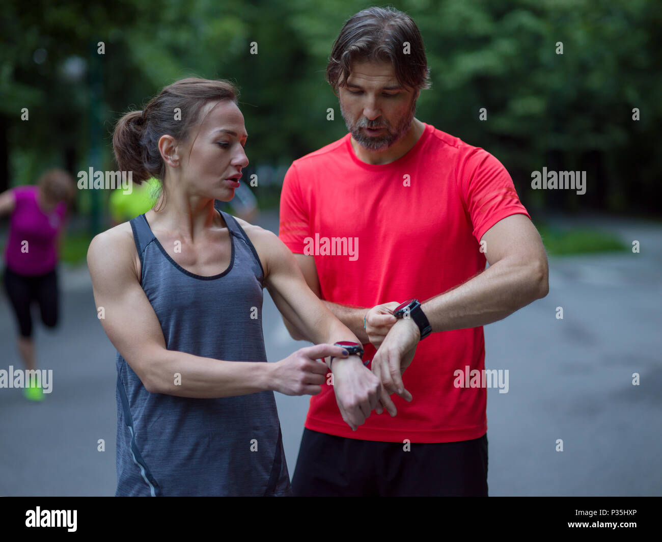 Junge sportliche Paar mit smart Uhren beginnen, ihre Timer vor dem Joggen Stockfoto