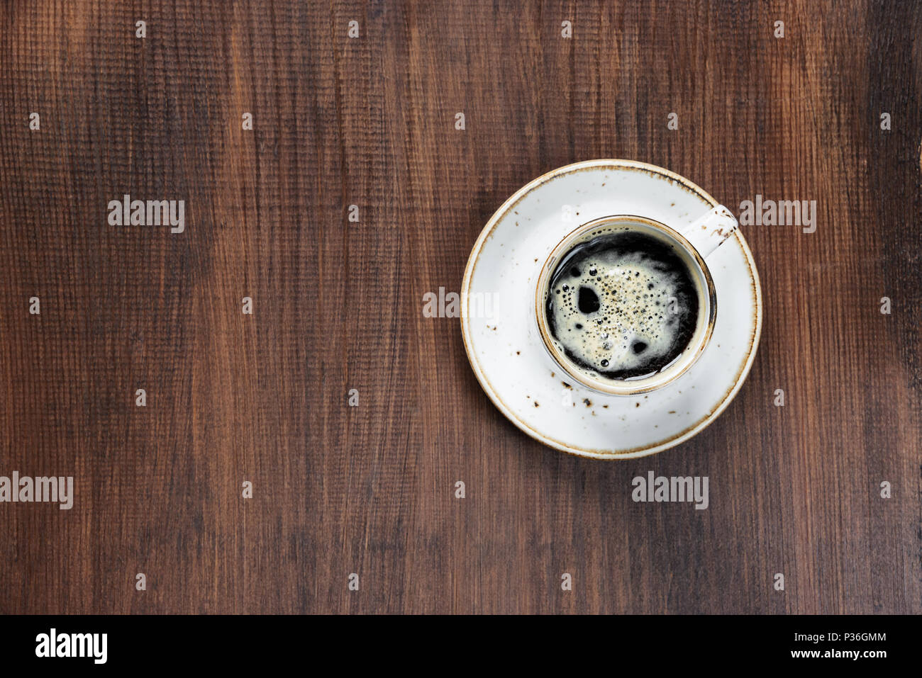 Vintage Porzellan Tasse schwarzen Kaffee mit Milchschaum auf dem hölzernen Hintergrund mit copy-Raum; Ansicht von oben Stockfoto