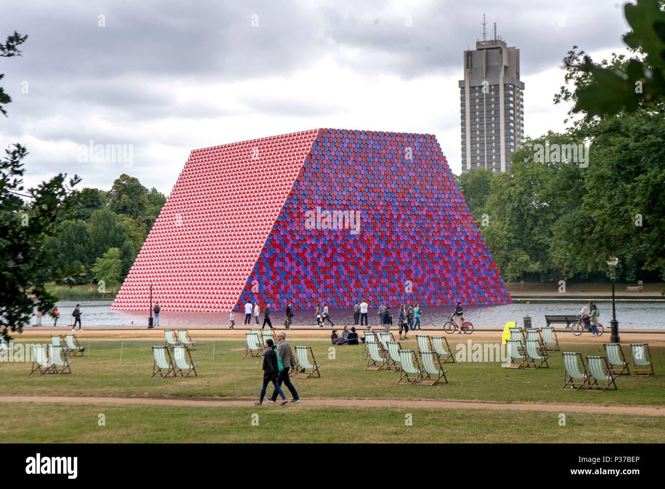 Leute, die in der Vergangenheit Christo erste BRITISCHE Arbeiten im Freien, die Mastaba, eine 20 m hohe Installation von 7,506 horizontal gestapelte Fässer, die 20 m hoch, 30 m breit und 40 m lang, auf See Serpentine Lake bis zum 23. September 2018 angezeigt werden. Stockfoto