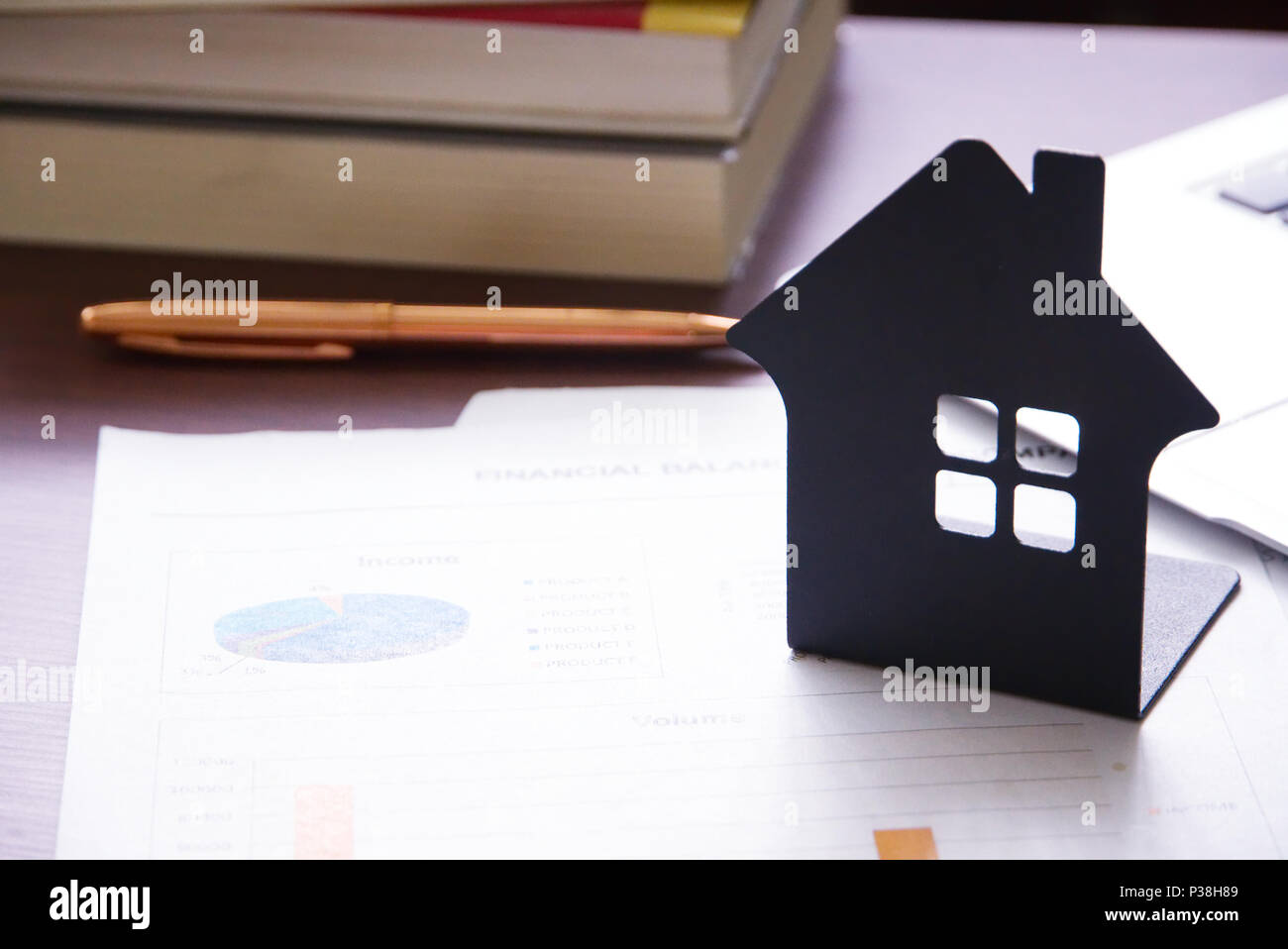 Haus Modell auf Dokument mit Hintergrund Stapel von Buch auf dem Tisch. Finanzen Konzept. Stockfoto