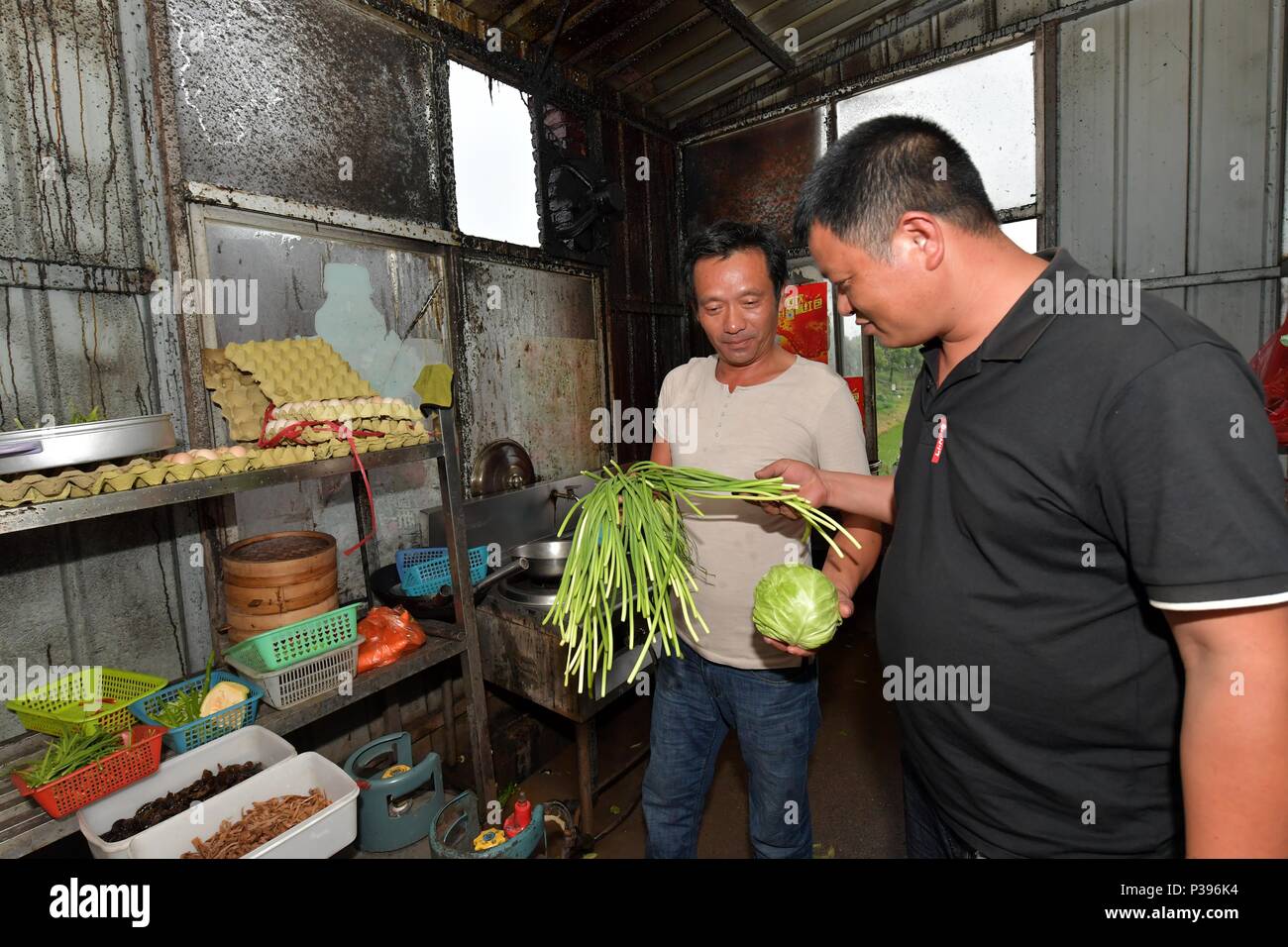 (180618) - Peking, 18. Juni 2018 (Xinhua) - Zou Yujiang (R) fragt nach dem Preis von Gemüse in einem Restaurant entlang der Bundesstraße 206, 12. Juni 2018. Zou hat jeden Cent, klug zu wegen des begrenzten Budgets auf der Straße verbringen. Zou Yujiang, 41 Jahre alt, ist ein LKW-Fahrer aus Gao'eine Stadt der Provinz Jiangxi. Er hat die meisten seiner Zeit auf der Straße verbracht, den Transport von Gütern von einem Ort zum anderen. Es wurden über 21 Millionen Beschäftigte in der Branche der Road Freight Transport in China bisher. Wie Zou Yujiang, die meisten von ihnen leben bei Fahrzeugen mit wenig Zeit stayi Stockfoto