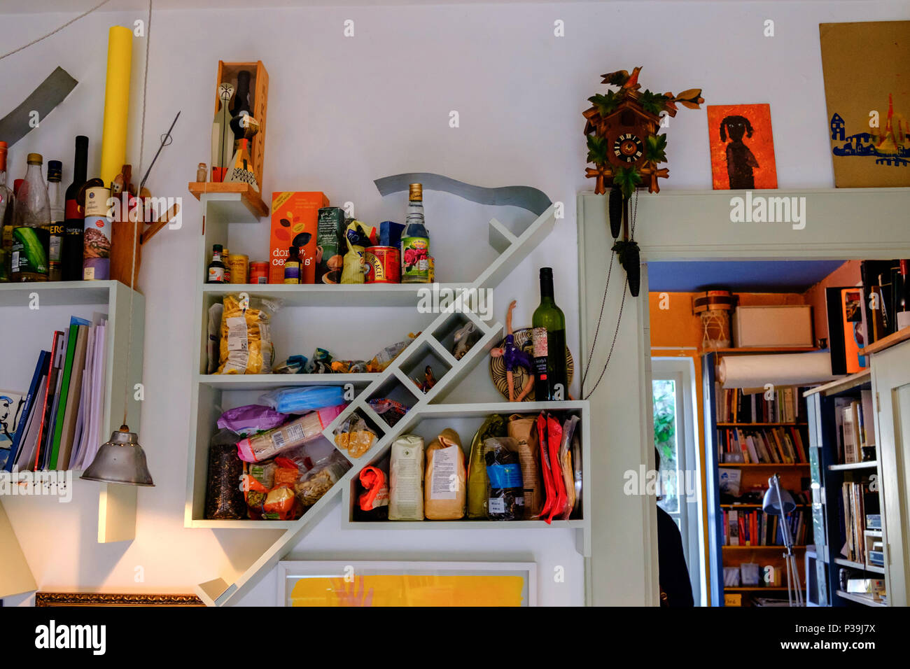 Offene Küche Regale mit Grundnahrungsmittel und Bücher, die in der Küche des Anpassungsfähig Haus, 6 Doughty Mews, Bloomsbury, London. Stockfoto