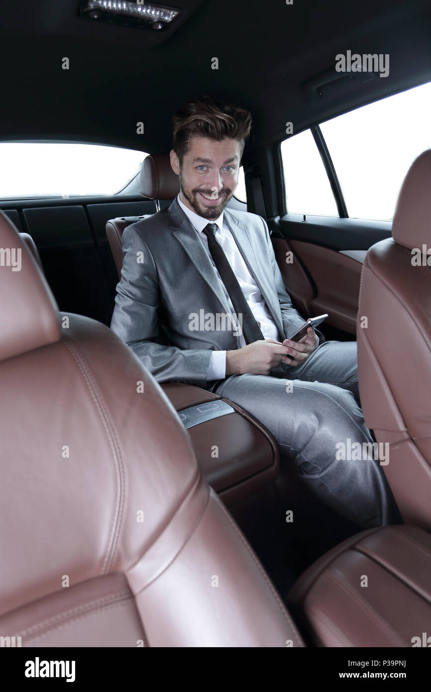 Mann in Anzug im Auto sitzen und Lesen von Nachrichten auf dem Smartphone  Stockfotografie - Alamy