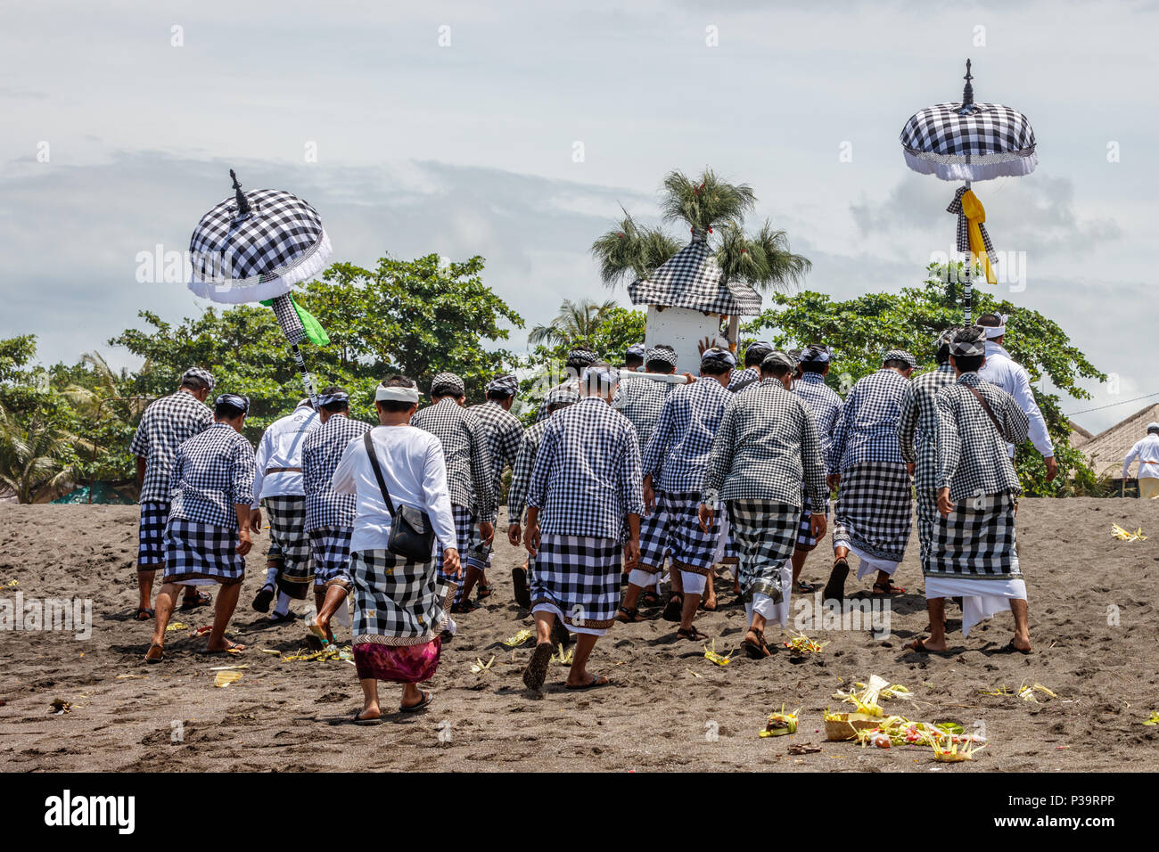 Balinesen in Schwarz und Weiß poleng Kleidung Wandern auf Seseh Strand gekleidet (Pantai Seseh), Bali, Indonesien. Melasti, hinduistischen Zeremonie. Stockfoto
