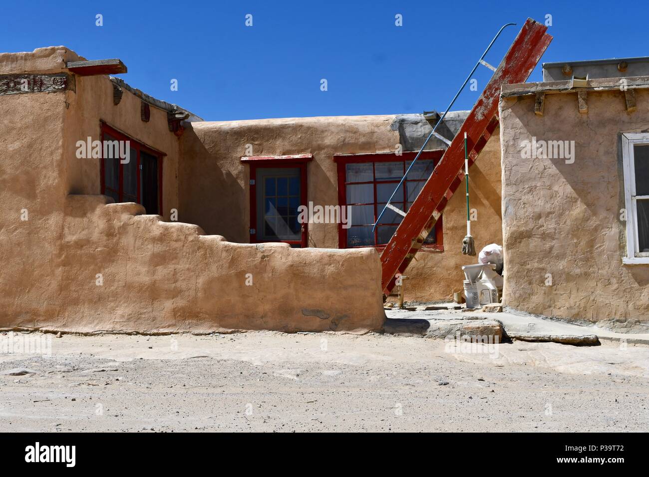 Roter Leiter mit baumelnden Mop in Acoma Pueblo Stockfoto