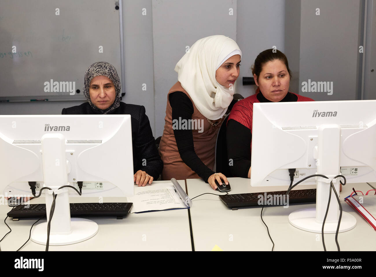 Berlin, Deutschland, Flüchtling Frauen erfahren, wie Sie den Computer zu benutzen Stockfoto
