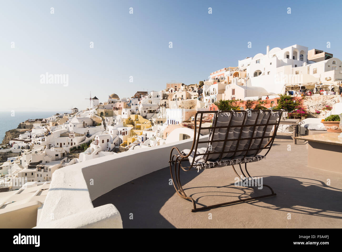 SANTORINI, Griechenland - Mai 2018: Iconic Panoramablick über das Dorf Oia auf Santorini, Griechenland. Schaukelstuhl im Vordergrund. Stockfoto