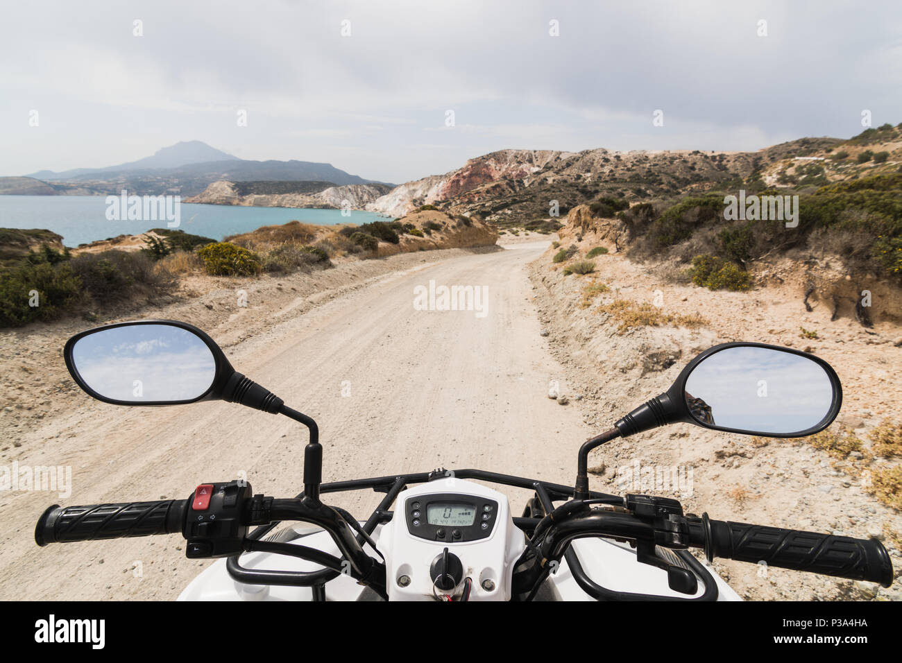 ATV Quad Bike auf der Küstenstraße entlang Ägäis auf Milos, Griechenland geparkt. Blick vom Fahrersitz Stockfoto