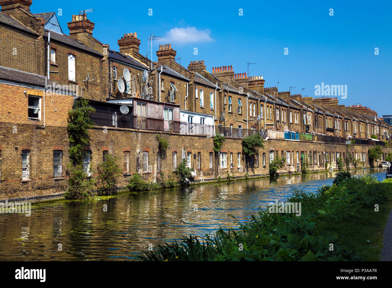 Die Rückseite der terrassierten Georgischen gemauerte Häuser durch die Regents Canal, Harrow Road, in der Nähe des Westbourne Park, London, UK Stockfoto