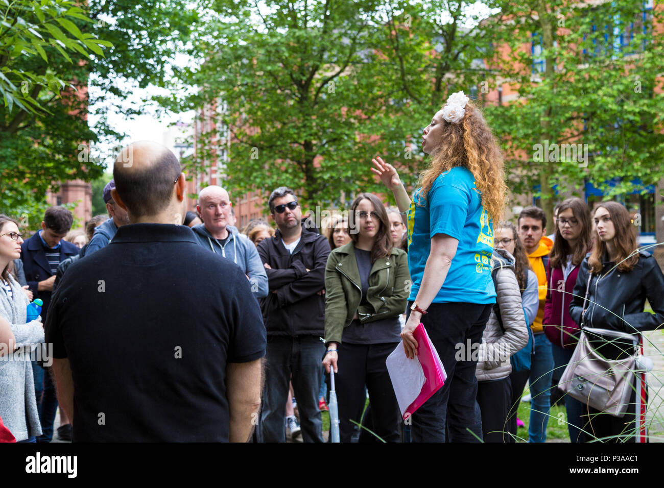 Eine Reisegruppe Hören zu einem Reiseleiter sprechen, Manchester, UK Stockfoto