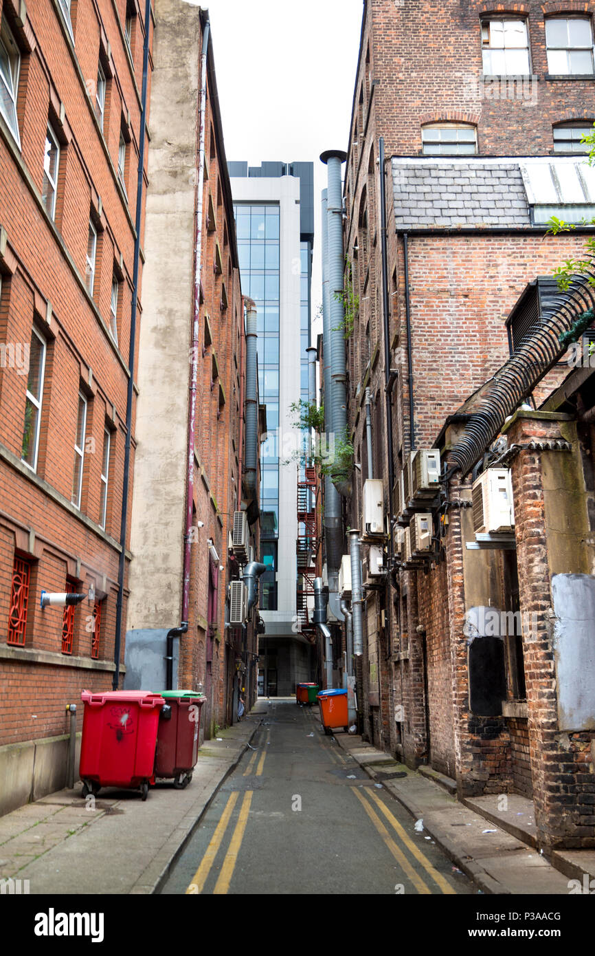 Enge Gasse in der Industrie mit Rohren und Behältern, Gebäude aus rotem Ziegel, in Manchester, Großbritannien Stockfoto