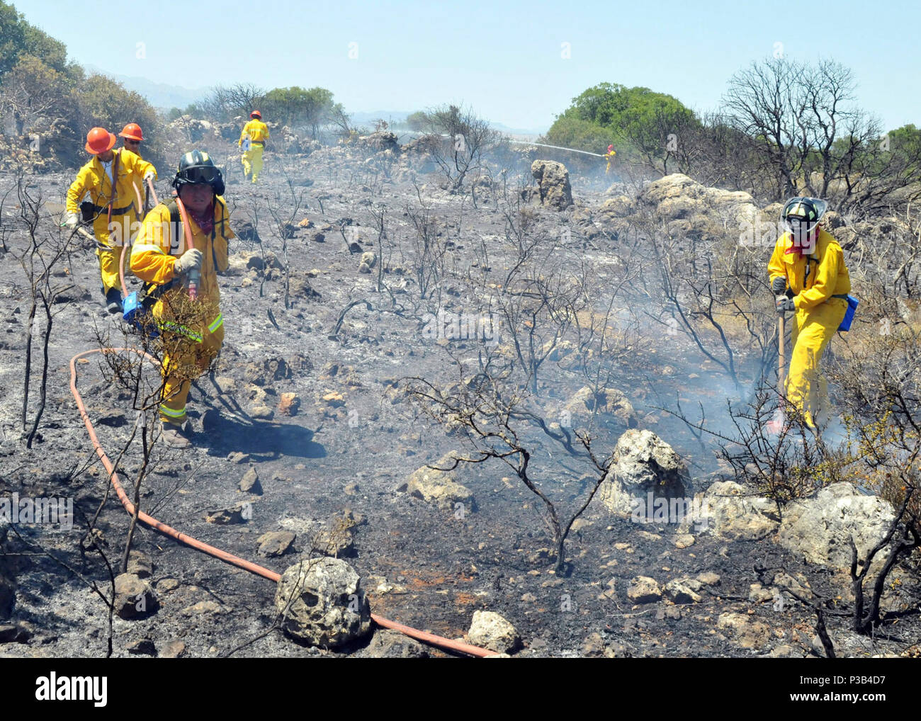 Feuerwehrmänner von Naval Support Activity Souda Bay die Überreste einer Bürste Feuer in der Nähe des Dorfes Pazinos im Westen Kretas, Griechenland, 11. Juli 2009 erlöschen. Die Feuerwehrmänner werden als Reaktion auf eine Anfrage auf Unterstützung von lokalen Stellen. Stockfoto