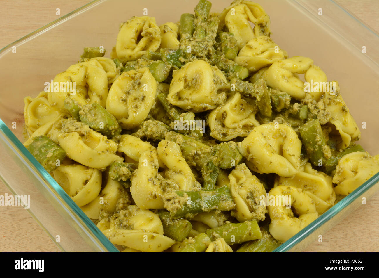 Vorbereitung der Käse Tortellini und Spargel pesto Kasserolle in Glas Auflaufform im Voraus für schnelle Wochentag Abendessen Stockfoto
