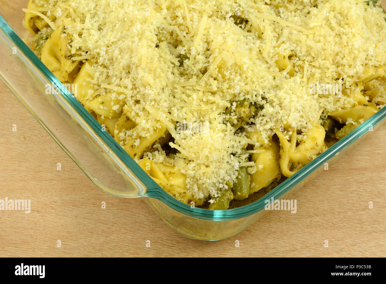Vorbereitung der Käse Tortellini und Spargel und geriebenem Käse Auflauf in Glas Auflaufform im Voraus für schnelle Abendessen unter der Woche Stockfoto