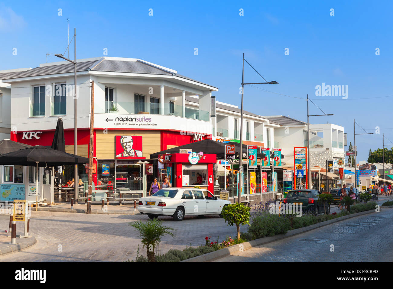 Ayia Napa, Zypern - 13. Juni 2018: Street View von Agia Napa Resort Stadt an der Südküste der Insel Zypern im Sommer Abend. Touristen zu Fuß auf der Straße Stockfoto