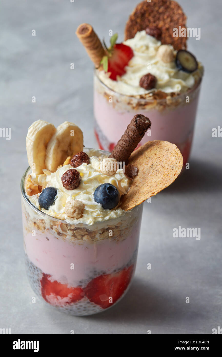 Müsli Joghurt Parfait mit frischen Beeren in Glas Tassen. Stockfoto