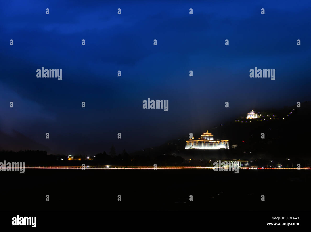 Der dzong von Paro leuchtet bis zu diesem schönen Sehenswürdigkeiten bei Nacht mit leichten Spuren von Autos Stockfoto