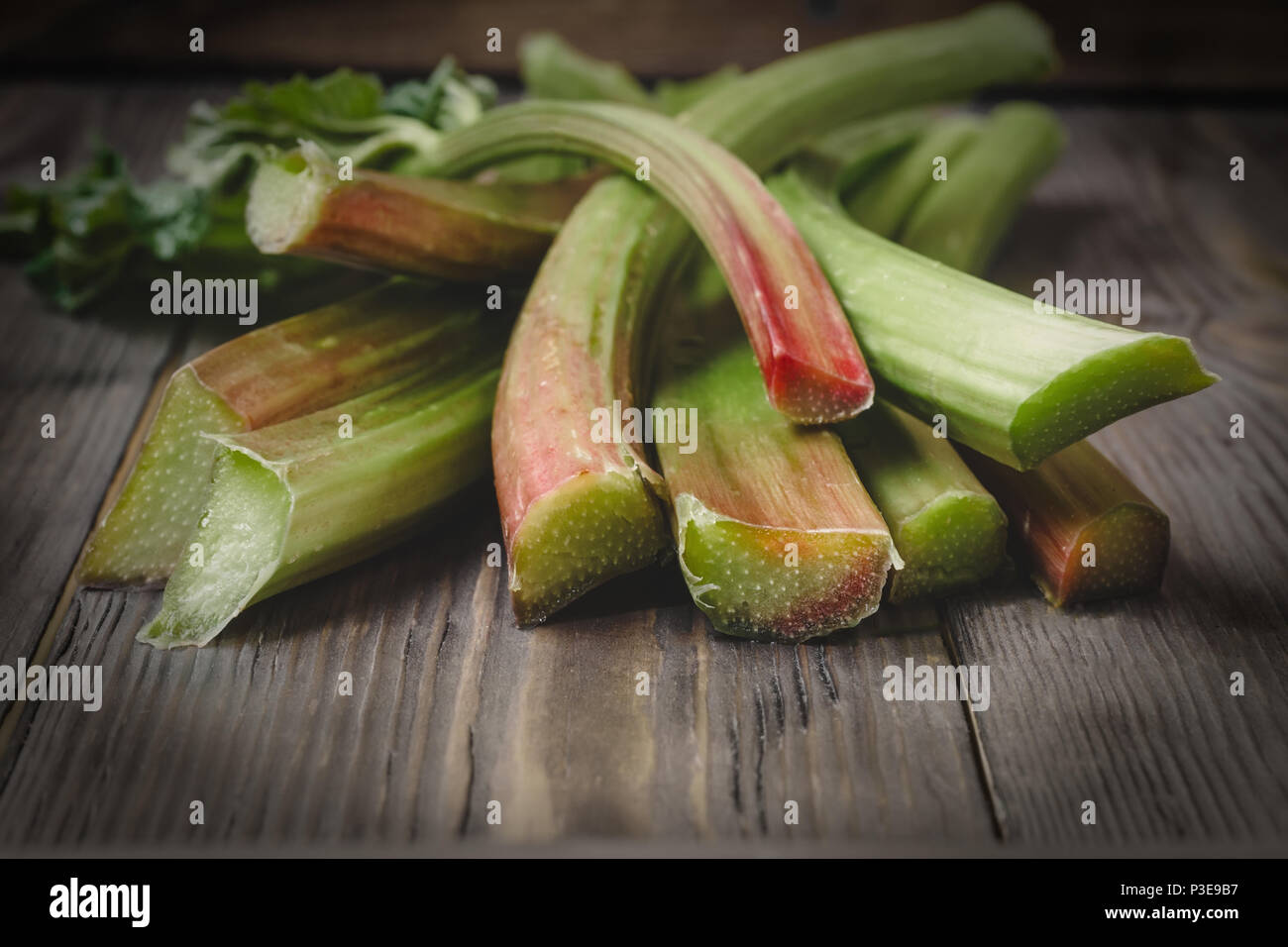Stämme der frische junge Rhabarber Zutaten für Lebensmittel Rezepte gesunde Ernährung detox Bio Lebensmittel Gemüse auf Holz- Hintergrund, Low Key kopieren Raum fo Stockfoto