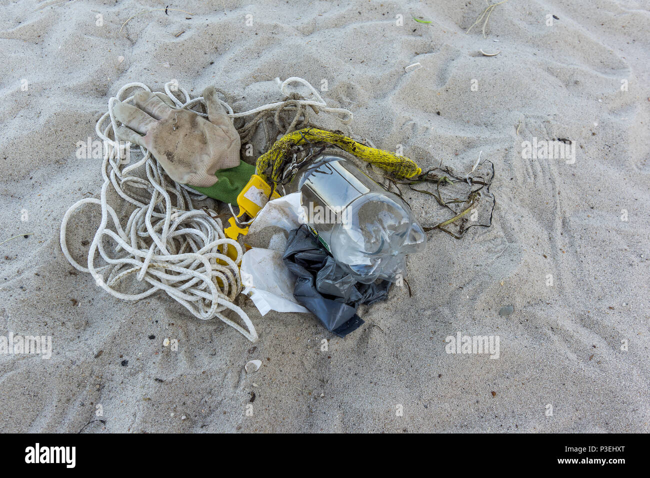 Eine Plastikflasche und anderen Müll auf den Sand, eine Nahaufnahme von einer verschmutzten Strand, Vejle, Dänemark, 6. Juni 2018 Stockfoto