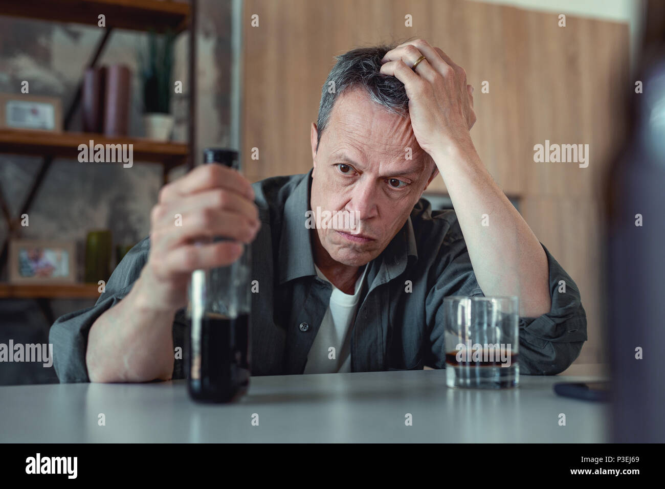 Dark-eyed Mann an der Flasche Cognac suchen Stockfoto