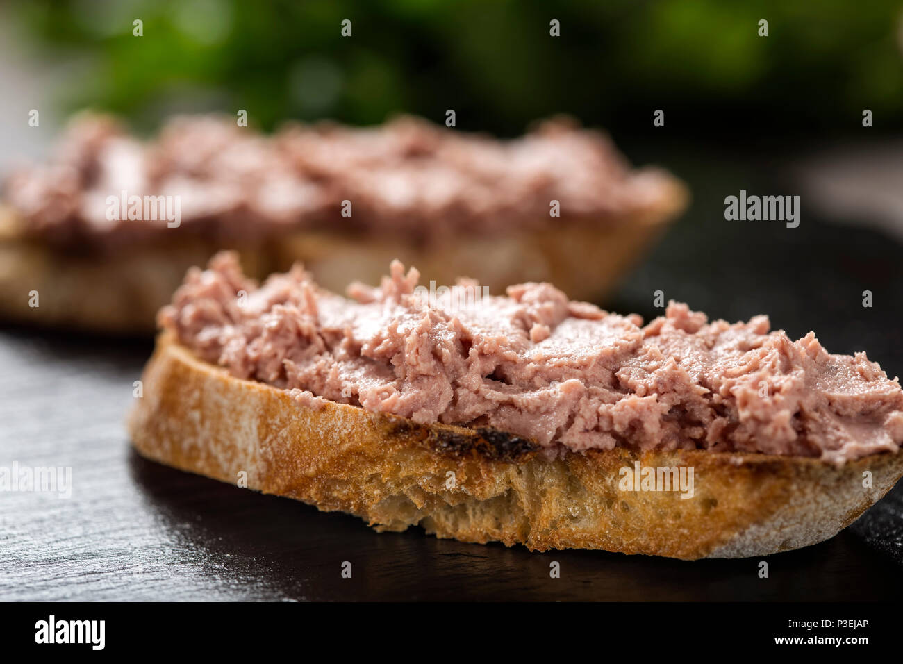 Leberwurst Sandwich auf dunklem Schiefer als detaillierte Nahaufnahme (selektive Fokus) Stockfoto