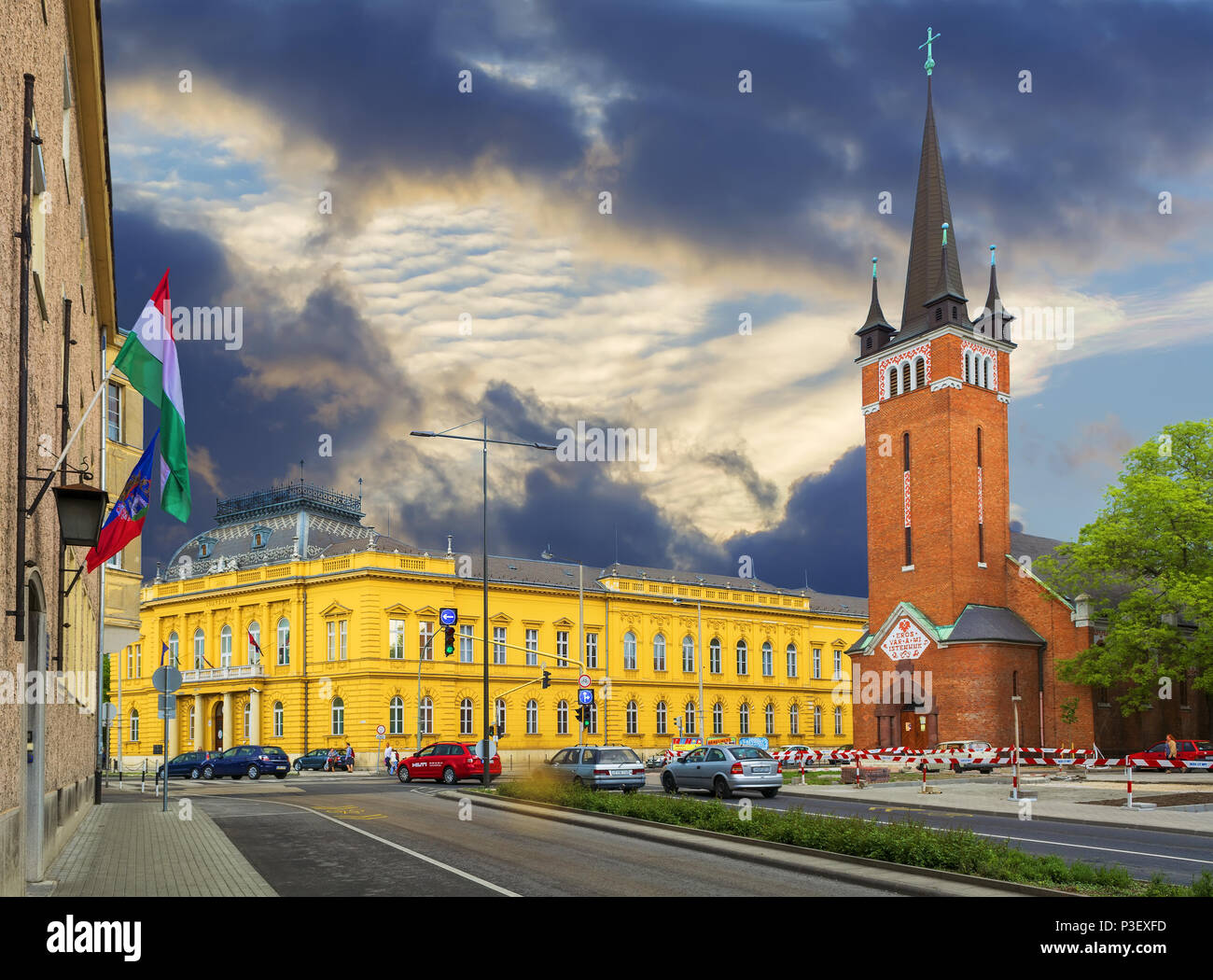 Die gelbe Gerichtsgebäude und die Evangelische Kirche aus rotem Backstein in Székesfehérvár, Ungarn. Székesfehérvár ist die Stadt der Könige und Kirchen. Stockfoto