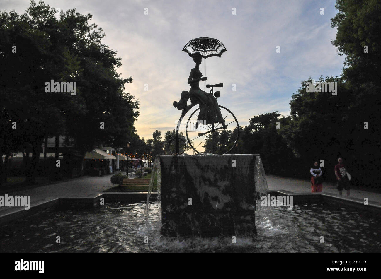 Die Statue einer Frau, ein Penny Farthing Fahrrad. In Batumi, Georgien fotografiert. Stockfoto