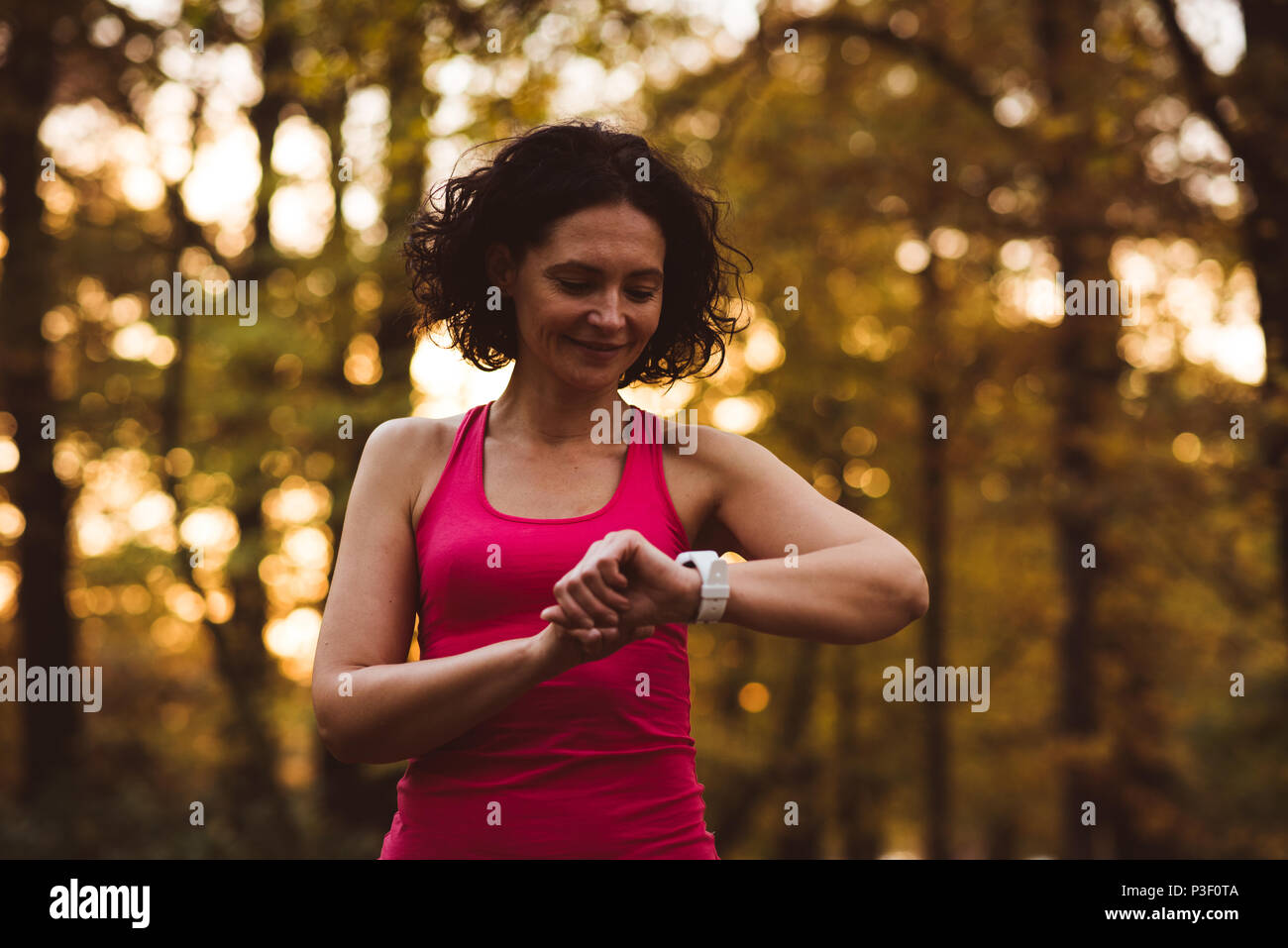 Frau mit smart Watch im Wald Stockfoto
