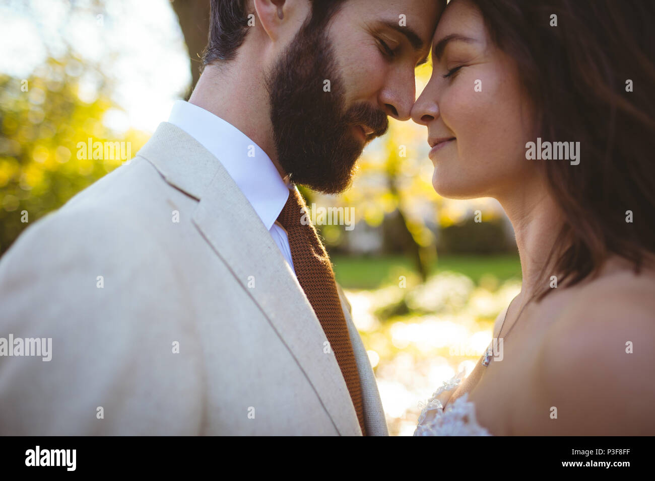 Braut und Bräutigam einander umarmen im Garten Stockfoto