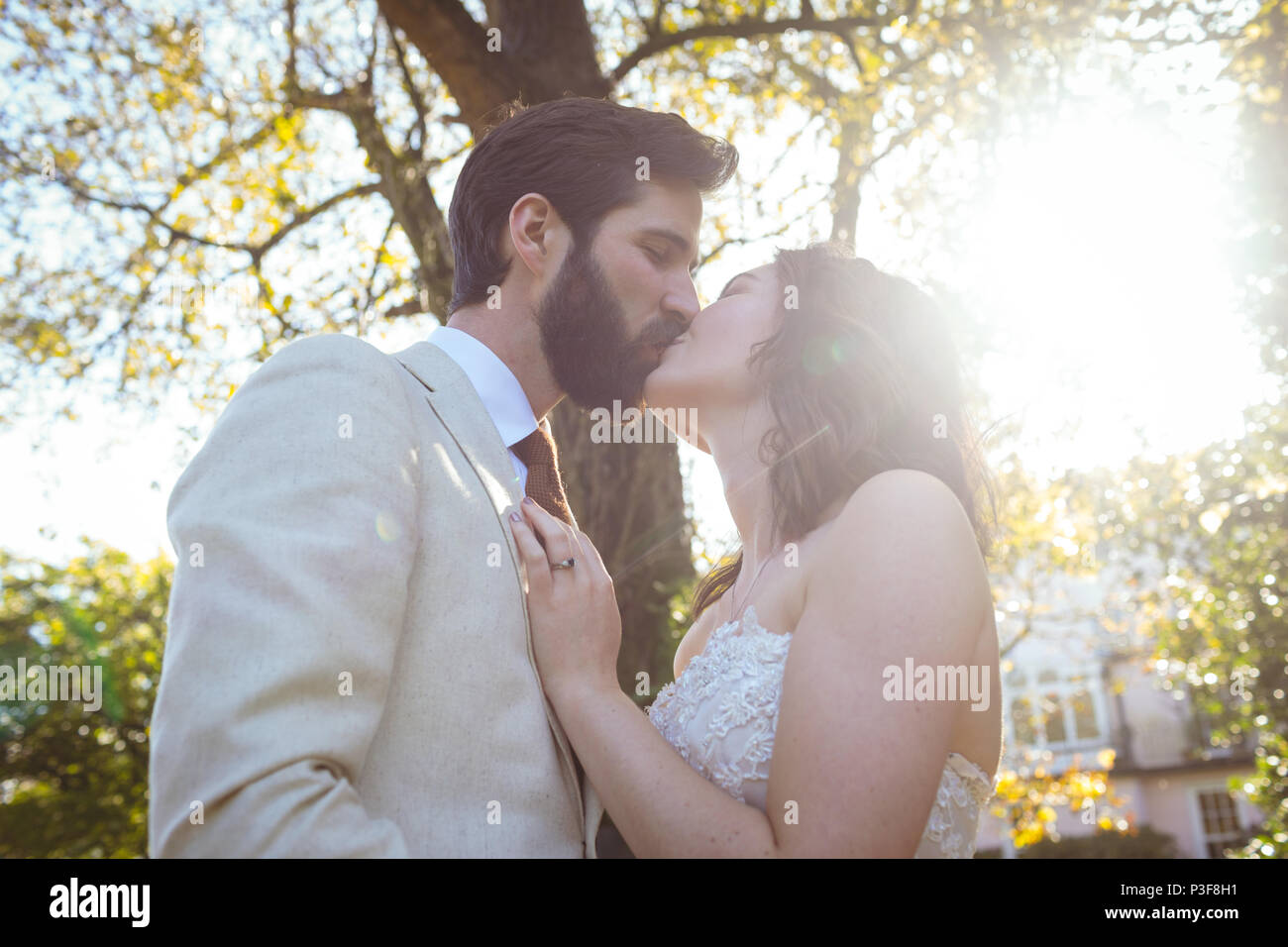 Braut und Bräutigam im Garten küssen Stockfoto