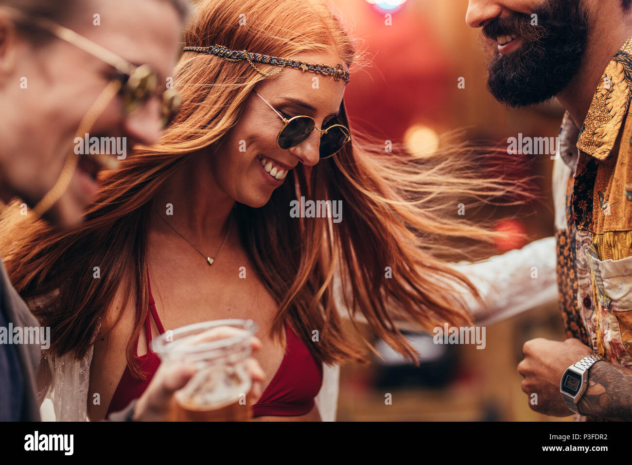 Hippie Mädchen tanzen mit einer Gruppe von Freunden bei Musik Festival. Junge Menschen, die tolle Zeit in Music Festival. Stockfoto