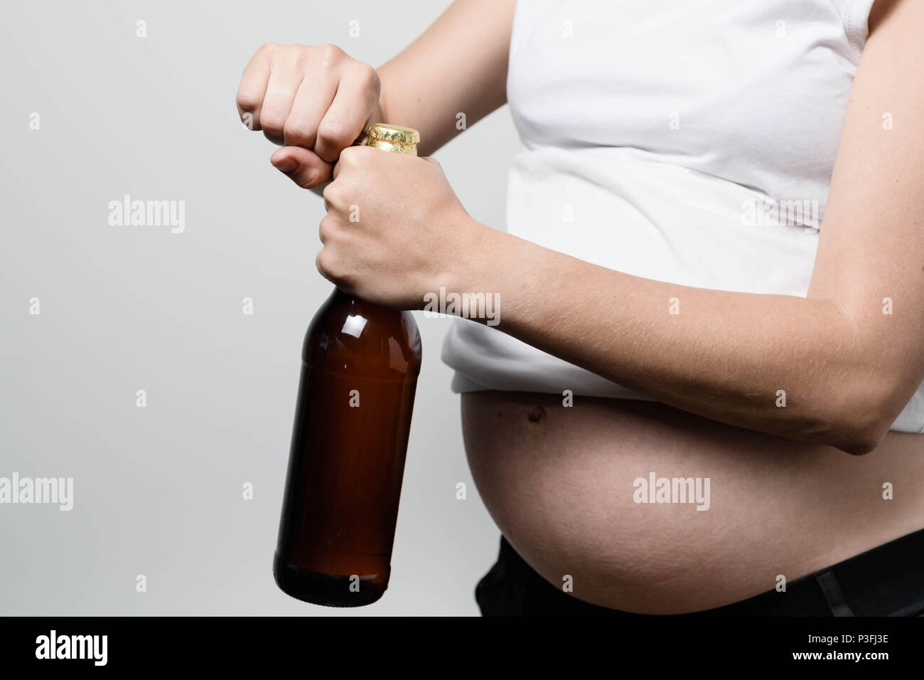 Schwangere Frau mit Bier Flasche Stockfoto