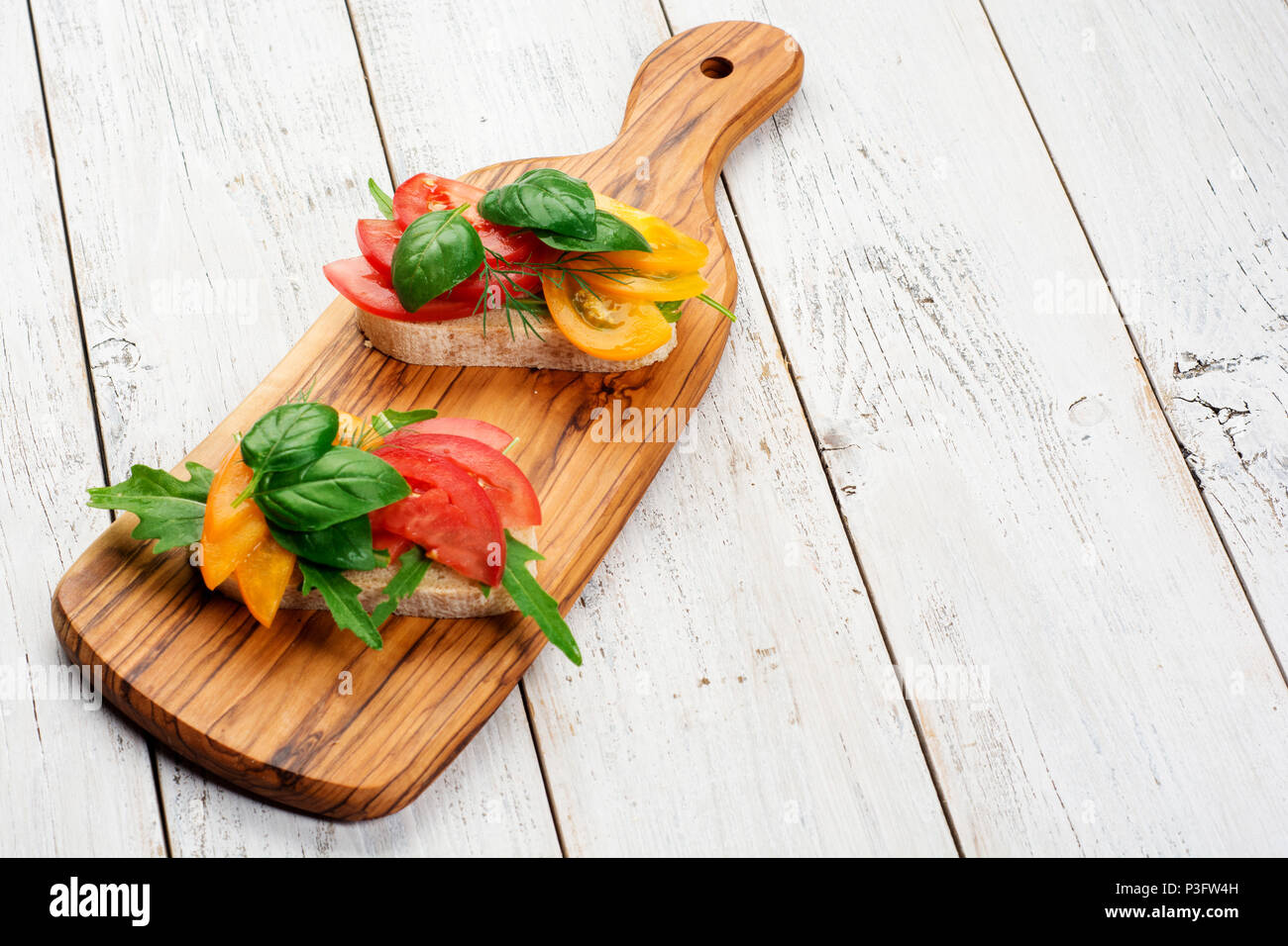 Italienische Bruschetta mit frischen Tomaten und Kräuter auf einem Schneidebrett mit Kopie Raum Stockfoto