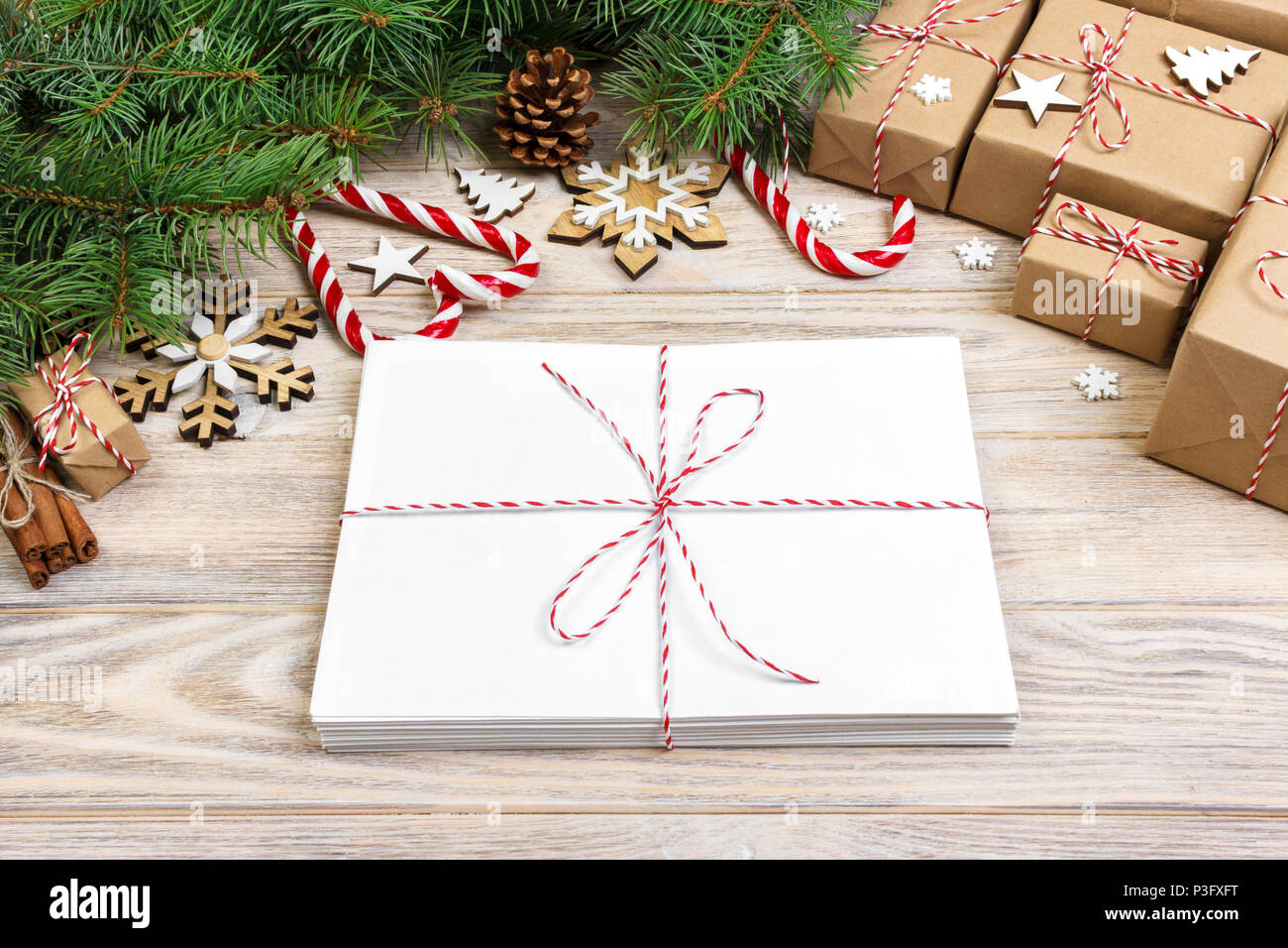 Umschlag mit leeren Blatt Papier auf Weihnachten Hintergrund-fir Zweig, Tannenzapfen, red ribbon, Sterne und Herzen von Süßigkeiten. Platz für Ihren Text. Stockfoto
