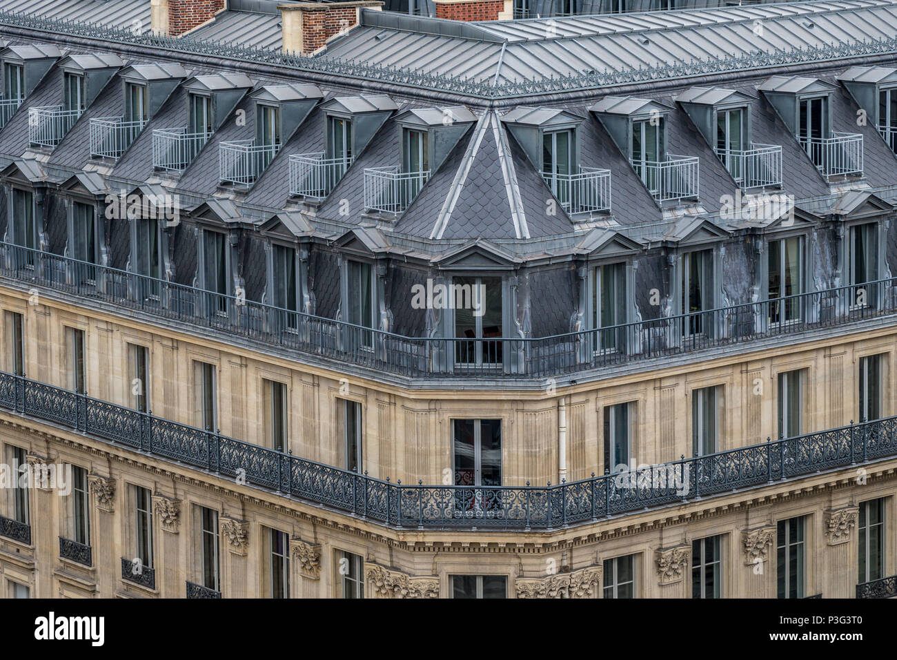 Die eleganten grauen Schiefer Dächer von Paris Apartment Gebäuden ein laufender Balkon und Zimmer im Dachgeschoss, Boulevard Haussmann, Paris, Frankreich Stockfoto