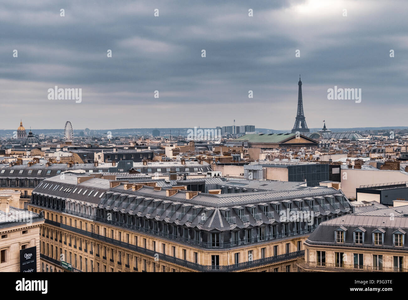 Der Eiffelturm und die eleganten grauen Schiefer Dächer von Paris Apartment Gebäuden ein laufender Balkon und Zimmer im Dachgeschoss, Boulevard Haussmann, Paris, Frankreich Stockfoto