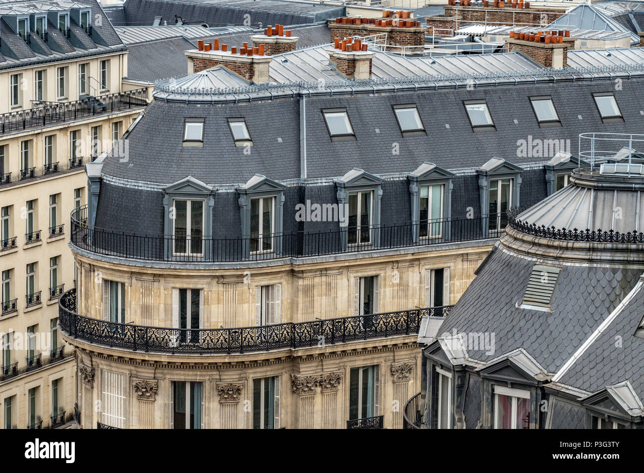 Die eleganten grauen Schiefer Dächer von Paris Apartment Gebäuden ein laufender Balkon und Zimmer im Dachgeschoss, Boulevard Haussmann, Paris, Frankreich Stockfoto