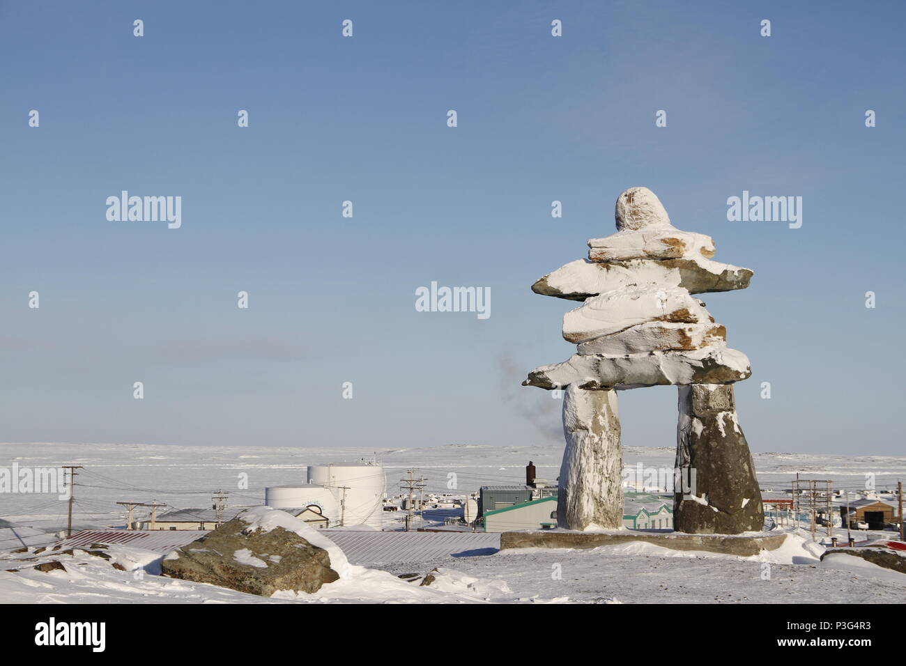 Inuksuk oder Inukshuk Wahrzeichen bedeckt mit Schnee auf einem Hügel in der Gemeinde Rankin Inlet, Nunavut, Kanada gefunden Stockfoto