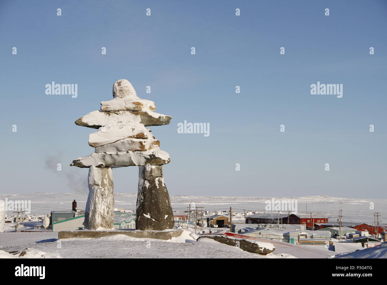 Inuksuk oder Inukshuk Wahrzeichen bedeckt mit Schnee auf einem Hügel in der Gemeinde Rankin Inlet, Nunavut, Kanada gefunden Stockfoto
