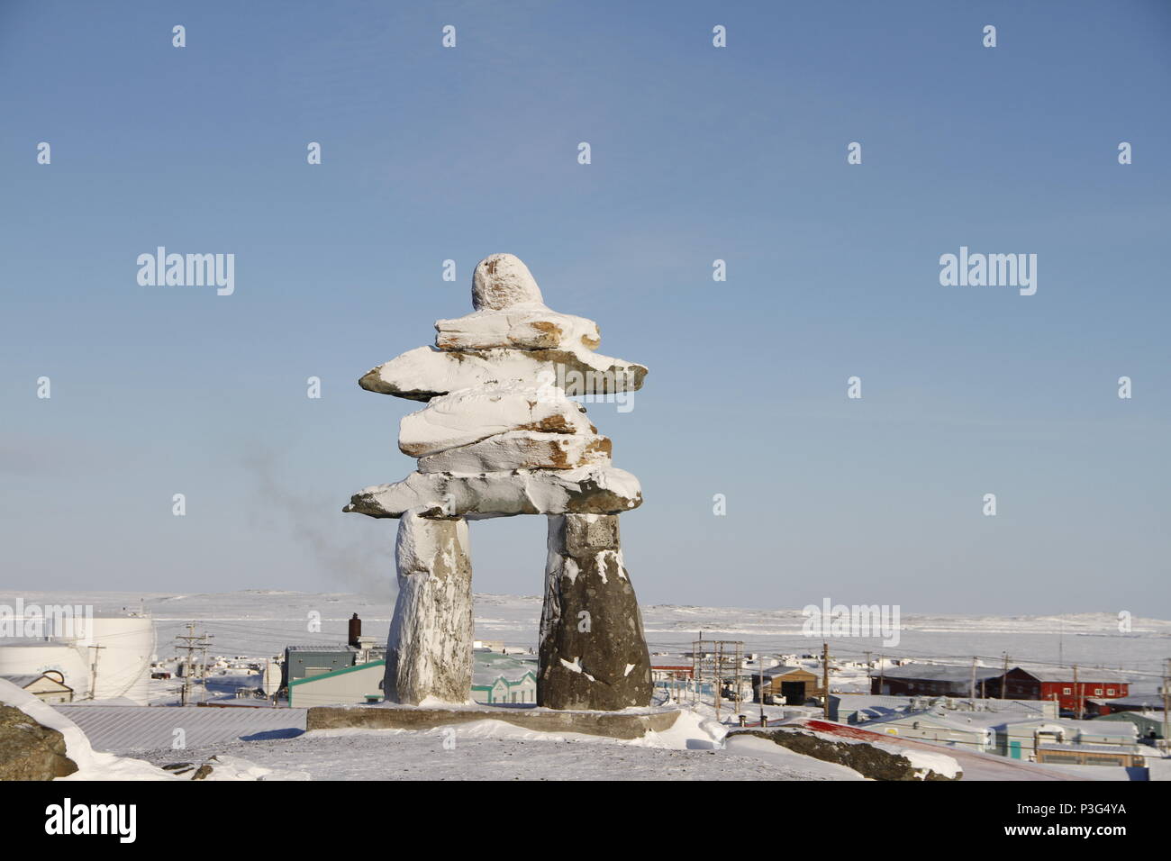 Inuksuk oder Inukshuk Wahrzeichen bedeckt mit Schnee auf einem Hügel in der Gemeinde Rankin Inlet, Nunavut, Kanada gefunden Stockfoto