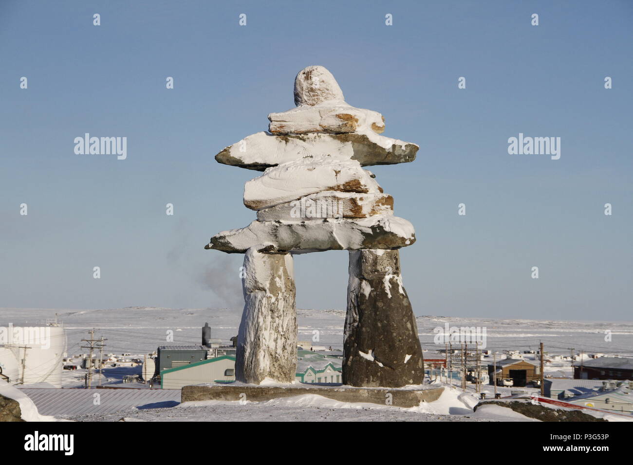 Inuksuk oder Inukshuk Wahrzeichen bedeckt mit Schnee auf einem Hügel in der Gemeinde Rankin Inlet, Nunavut, Kanada gefunden Stockfoto