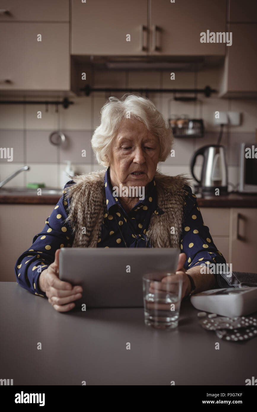 Ältere Frau mit digitalen Tablet in der Küche Stockfoto