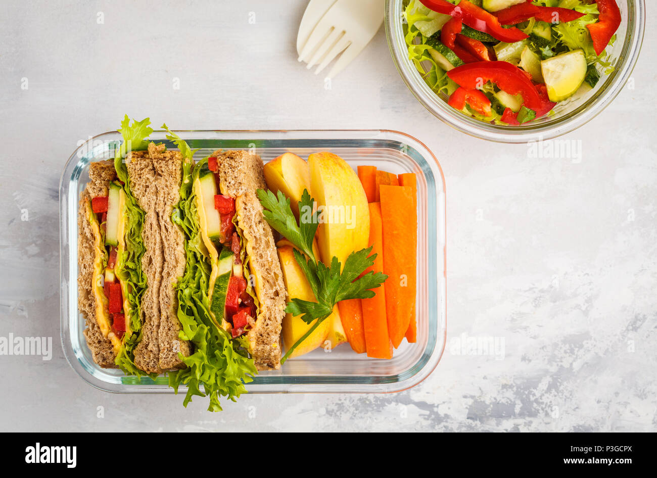 Gesunde Mahlzeit prep Glasbehälter mit Käse Gemüse Sandwiches und Salat overhead Shot mit Kopie Raum Stockfoto