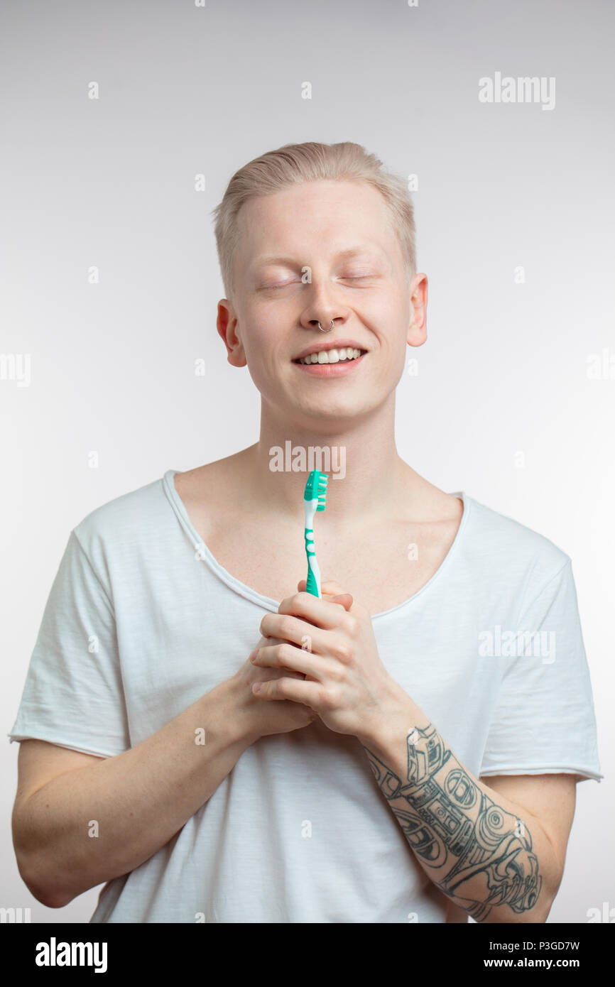 Mann mit geschlossenen Augen holding Zahnbürste in der Hand. Zahnpflege Zähne und Gesundheit Stockfoto