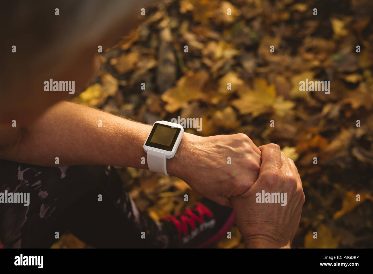 Ältere Frau mit einem smart Watch in einem Park Stockfoto