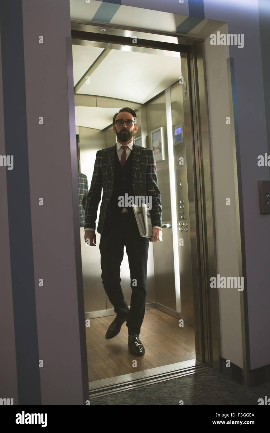 Geschäftsmann aus dem Aufzug Stockfoto