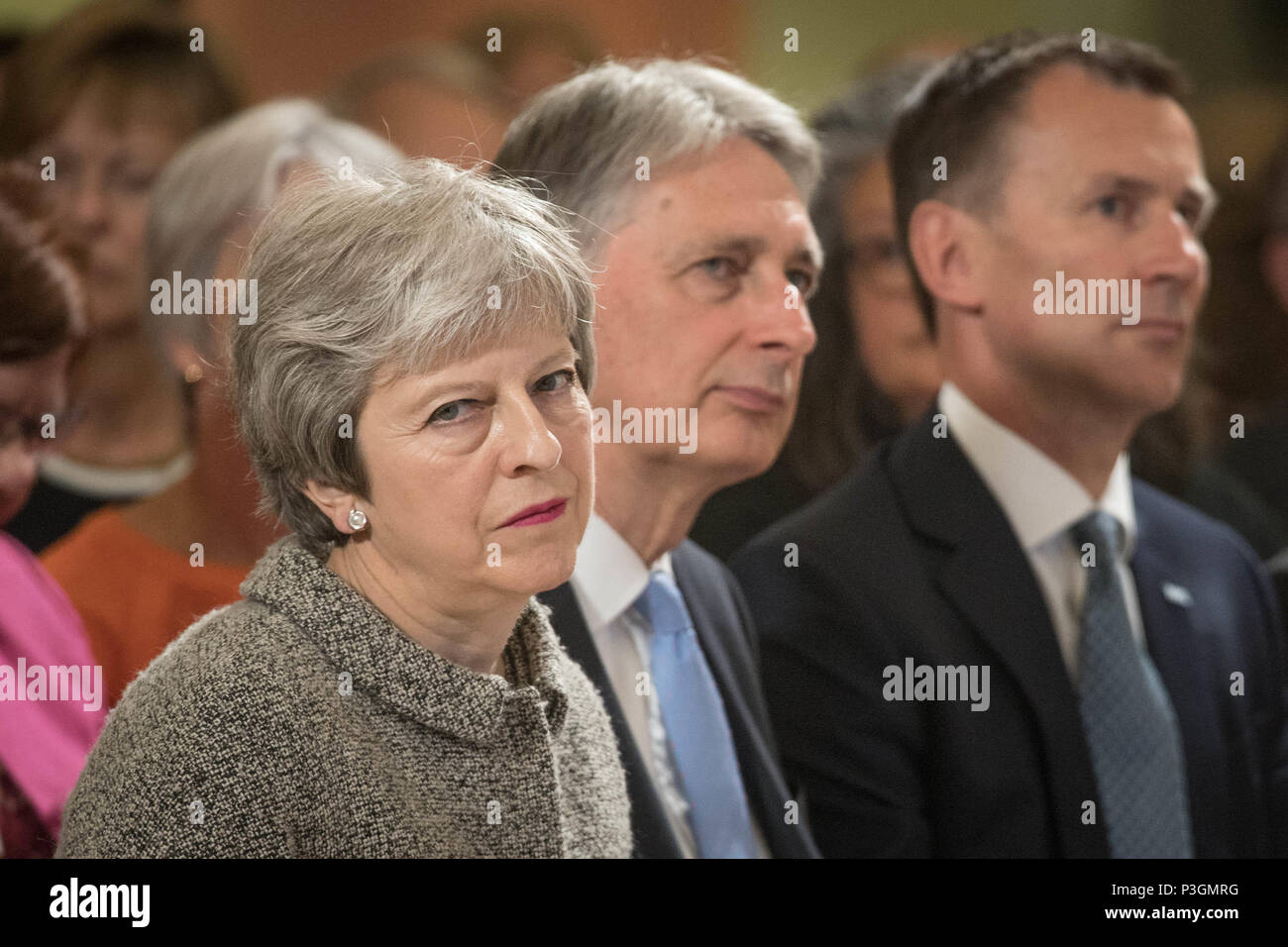 Premierministerin Theresa May hört zu, neben dem Schatzkanzler Philip Hammond und dem Gesundheitsminister Jeremy Hunt (rechts), bevor sie eine Rede im Royal Free Hospital, im Norden Londons, nach der Ankündigung einer Erhöhung der NHS-Mittel, hält. Wo sie darlegte, wie die Ausgaben für das Gesundheitswesen bis 2024 real um £384 Millionen pro Woche steigen werden. Stockfoto