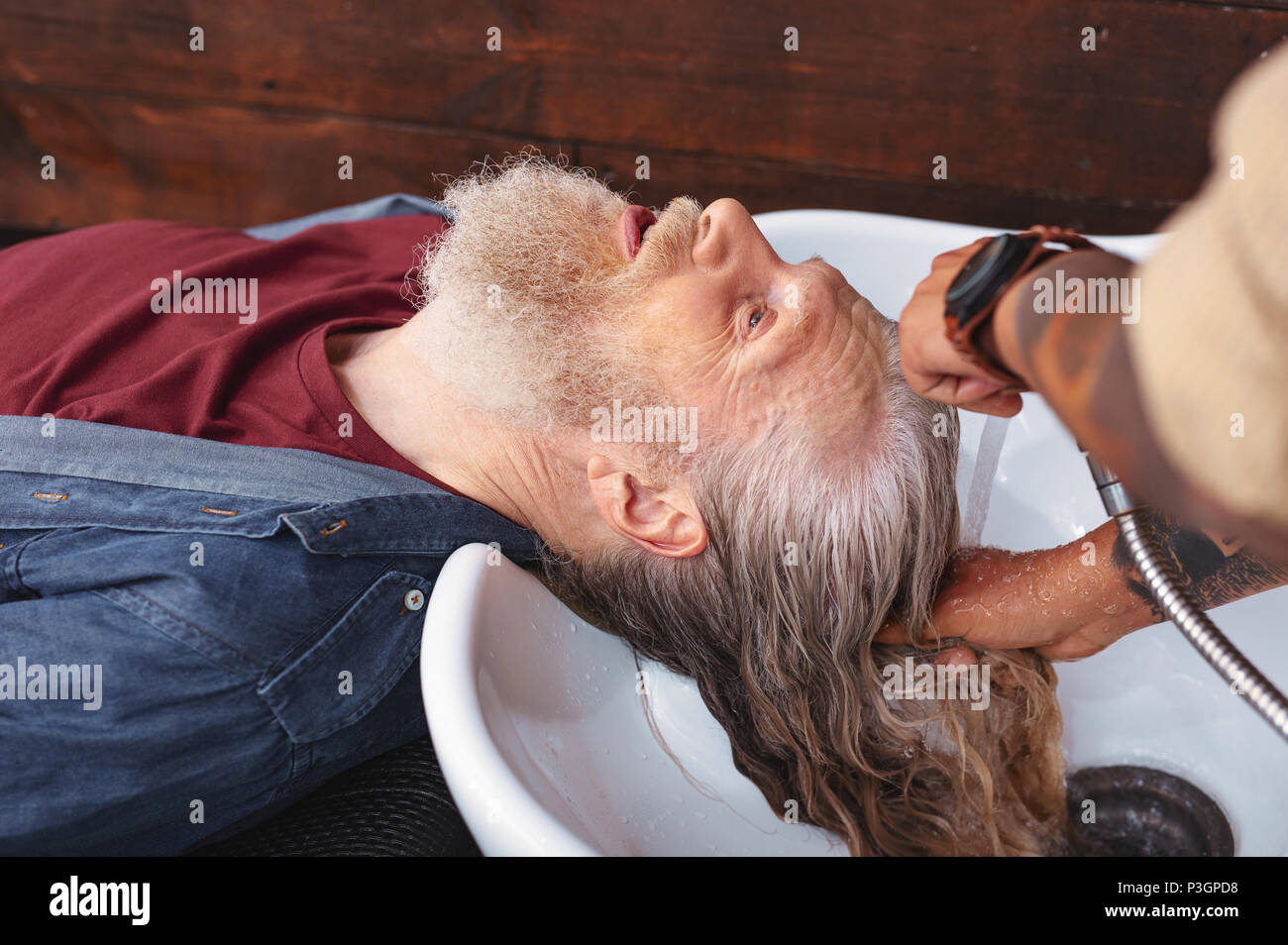 Ernsthafte grauhaarige männliche Person, Salon Stockfoto