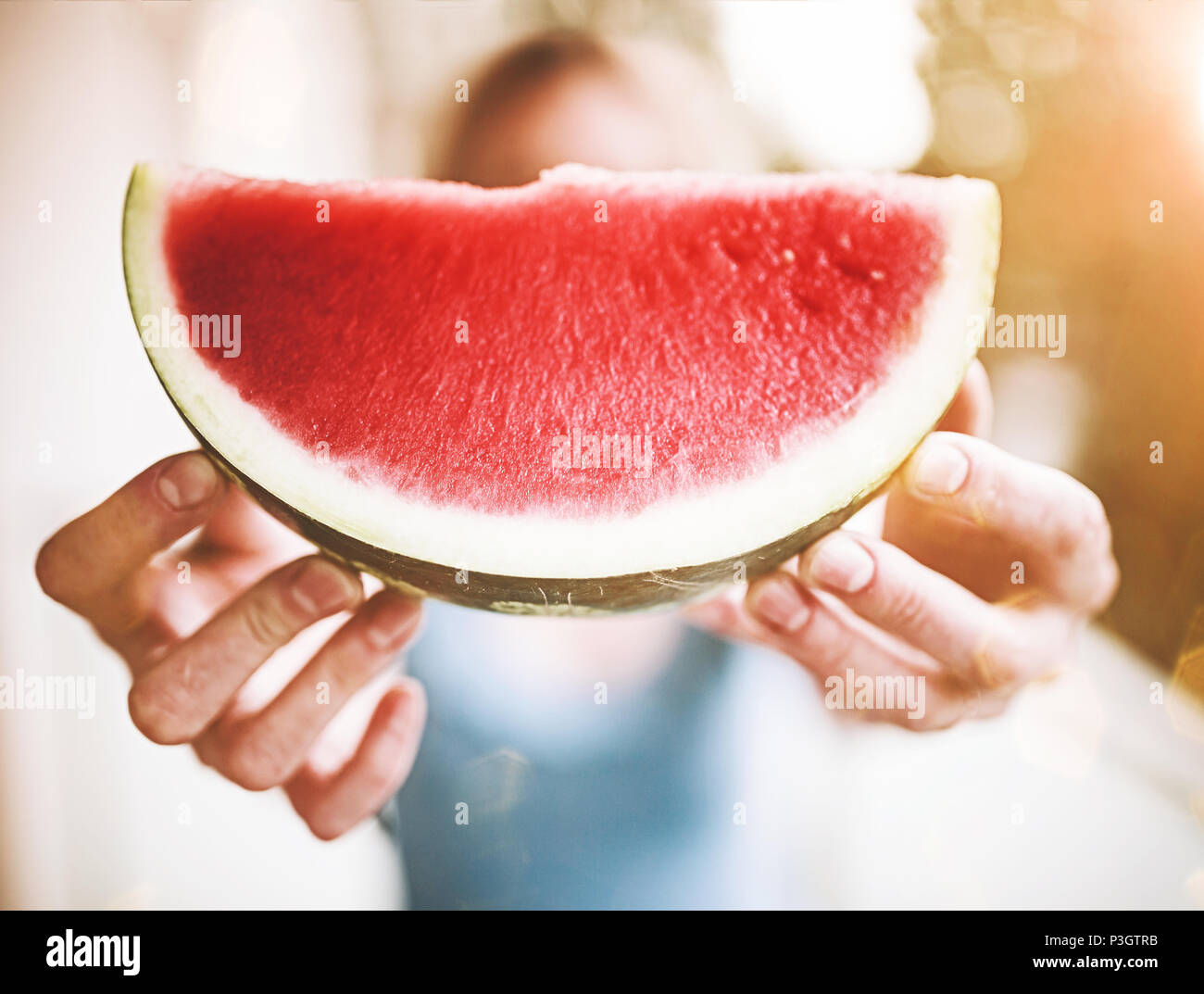 Blonde Frau hält ein Stück saftige frische Wassermelone Stockfoto