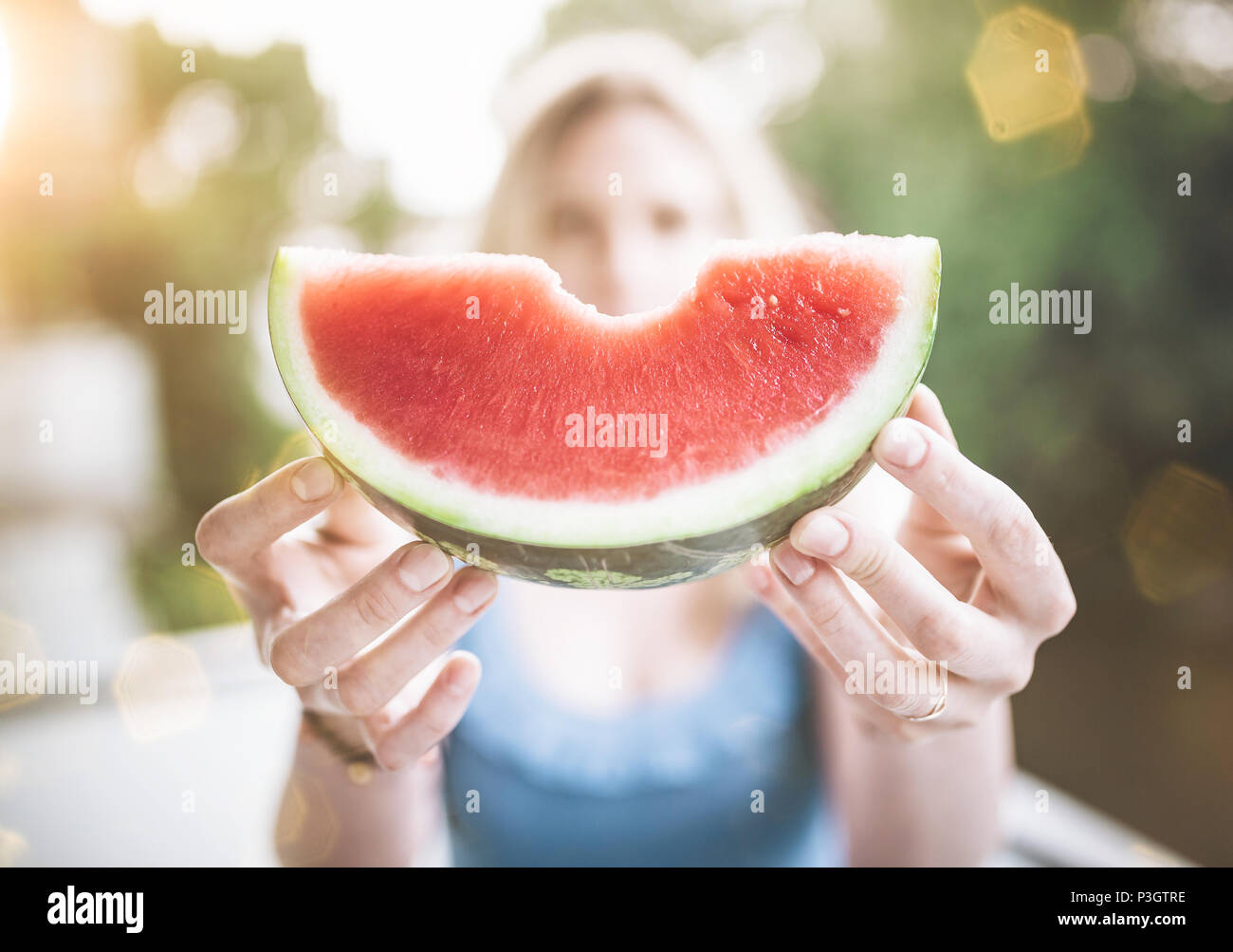 Blonde Frau hält ein Stück saftige frische Wassermelone Stockfoto
